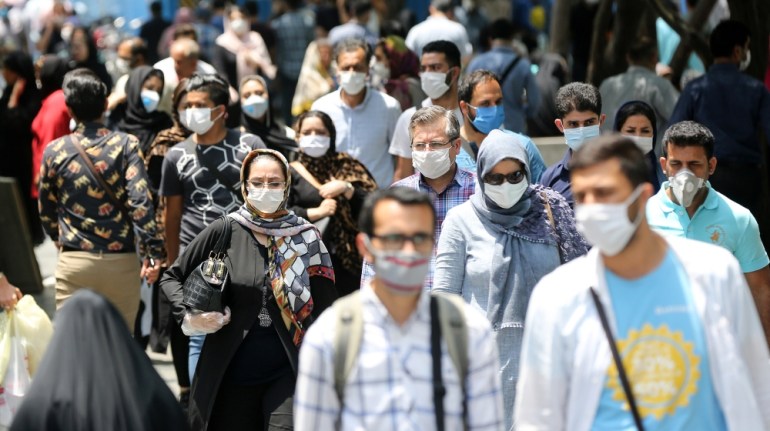 People wearing protective maska walk through a street as Iran makes wearing masks mandatory in public, in Tehran, Iran on July 5, 2020. (Photo by Fatemeh Bahrami/Anadolu Agency via Getty Images)