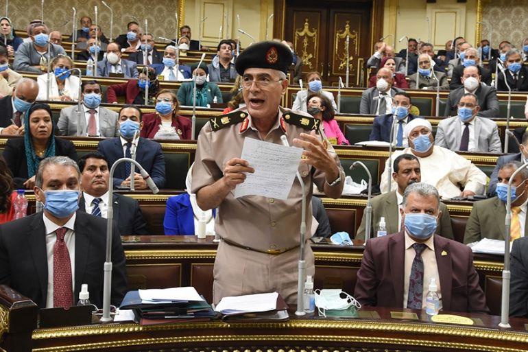 epa08557074 Egyptian General Mamdoh Shahen (2-L) holds up handwritten notes as he speaks during a parliamentary debate session to discuss and vote whether Egypt should send troops to the neighboring c