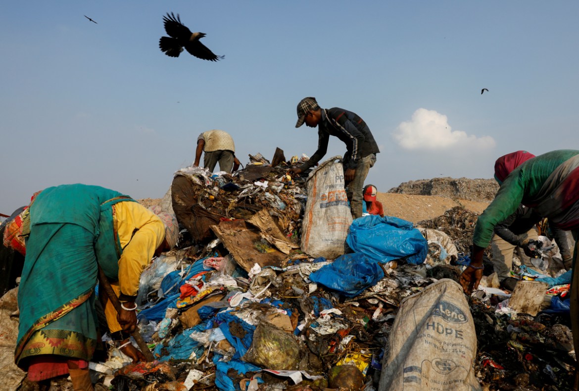 Waste collectors look for recyclable materials among bags of disposed medical waste at a landfill site, during the coronavirus disease (COVID-19) outbreak, in New Delhi, India, July 9, 2020. REUTERS/A