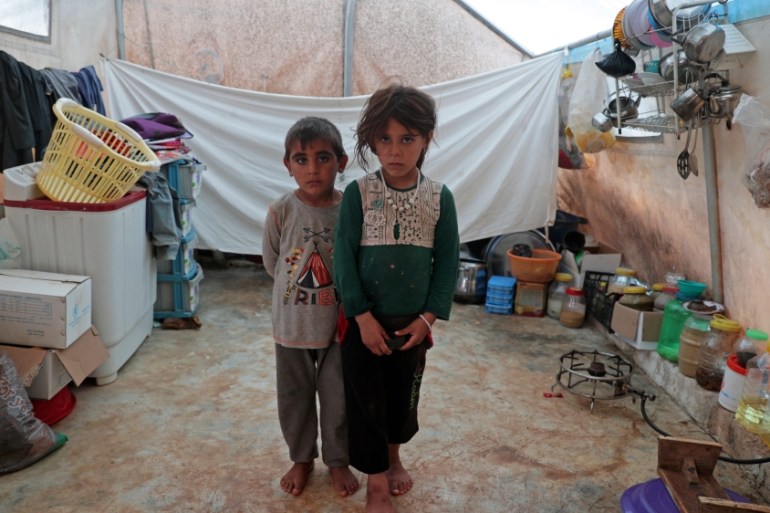 Jumana and Farhan al-Alyawi, 8-year-old displaced Syrian twins from east Idlib, pose for a picture in a tent at Atmeh Camp