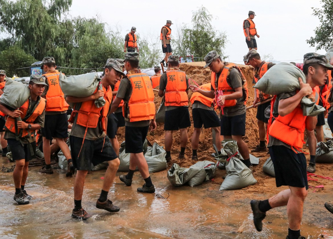 This photo taken on July 13, 2020 shows Chinese soldiers building an emergency levee along the shore of Boyang lake to contain flooding due to seasonal rains and the swollen Yangtze River in Jiujiang