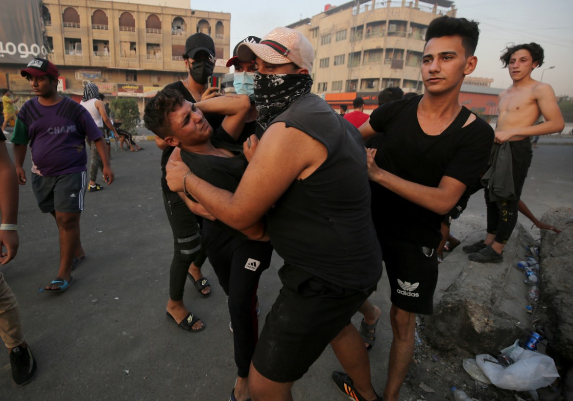 Iraqi demonstrators clash with security forces in al-Tayaran square in central Baghdad on July 27, 2020 during the ongoing anti-government protest due to poor public services. (Photo by AHMAD AL-RUBAY
