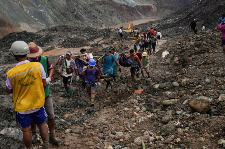Rescuers recover bodies near the landslide area in the jade mining site in Hpakhant in Kachin state on July 2, 2020. The battered bodies of more than 120 jade miners were pulled from a sea of mud afte