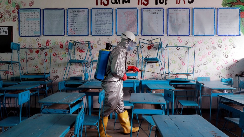 An officer sprays disinfectants inside a class room at a school as the Sri Lanka's government expects to re-open schools after almost two months of lock down amid concerns a