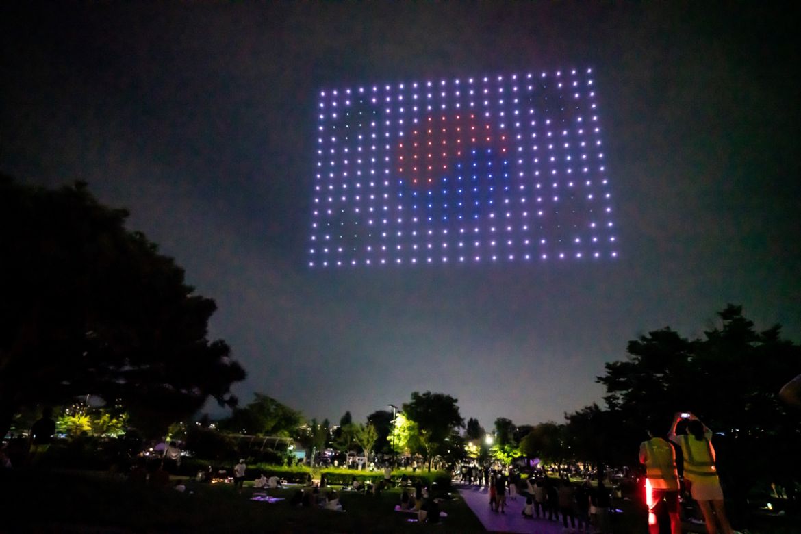 This handout photo taken on July 4, 2020 and released on July 6 by South Korea''s Ministry of Land, Infrastructure, and Transport shows people taking photos of a drone display showing messages of suppo