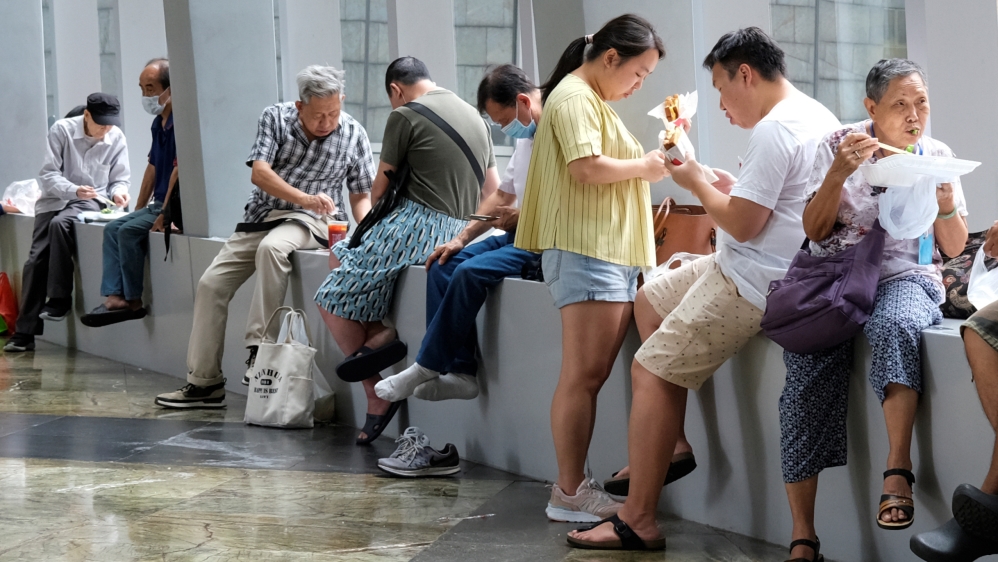People have lunch at a mall after the government banned dine-in services, following the coronavirus disease (COVID-19) outbreak in Hong Kong