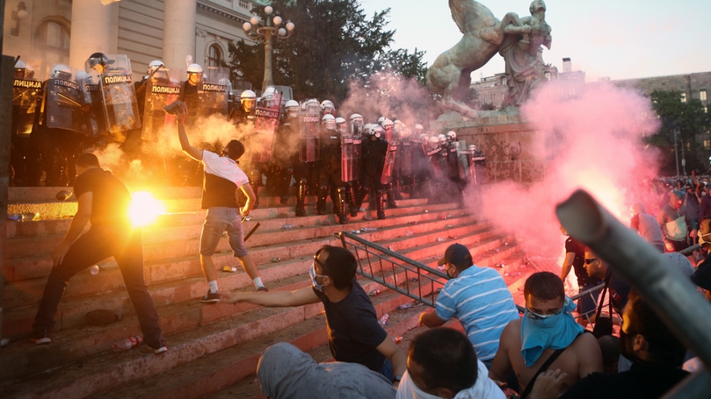 Protestors clash with police in Belgrade on July 8, 2020 as violence erupts against a weekend curfew announced to combat a resurgence of COVID-19 infections despite Serbia's President Aleksandar Vucic