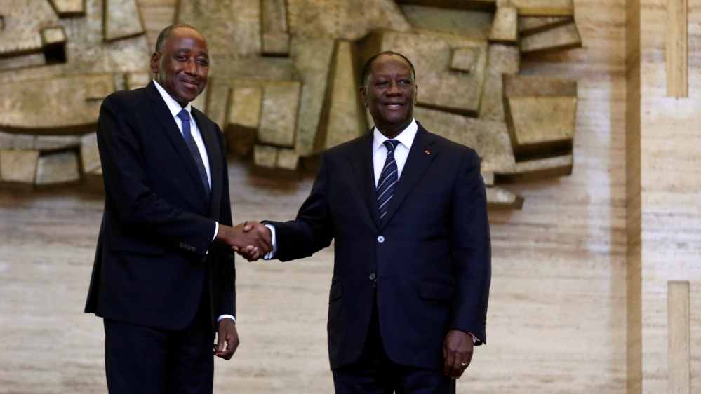 FILE PHOTO: Ivory Coast President Alassane Ouattara and new Prime Minister Amadou Gon Coulibaly pose for pictures in the Presidential Palace in Abidjan