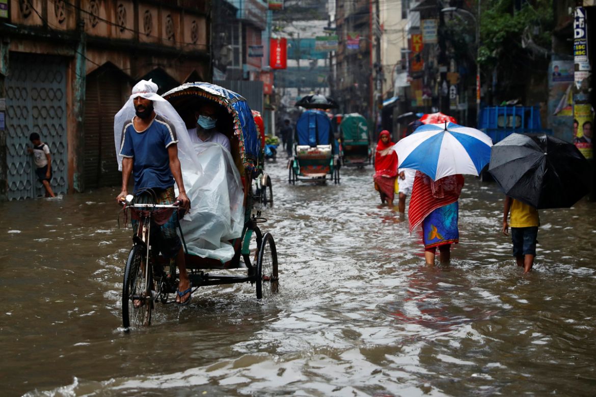 Commuters move through a water-logged street after heavy rain in Dhaka, Bangladesh, July 21, 2020. REUTERS/Mohammad Ponir Hossain