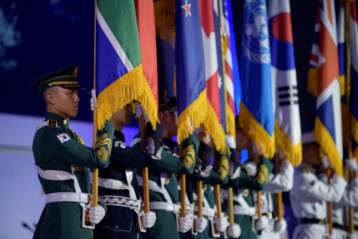Members of a military honour guard hold the flags of participating nations during a UN Forces Participation Day event marking the anniversary of the signing of the Korean War armistice agreement, in S