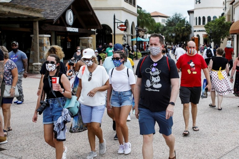 Disney Springs shoppers wear face masks and Disney-themed clothing while Walt Disney World conducts a phased reopening from coronavirus disease (COVID-19) restrictions in Lake Buena Vista, Florida, U.