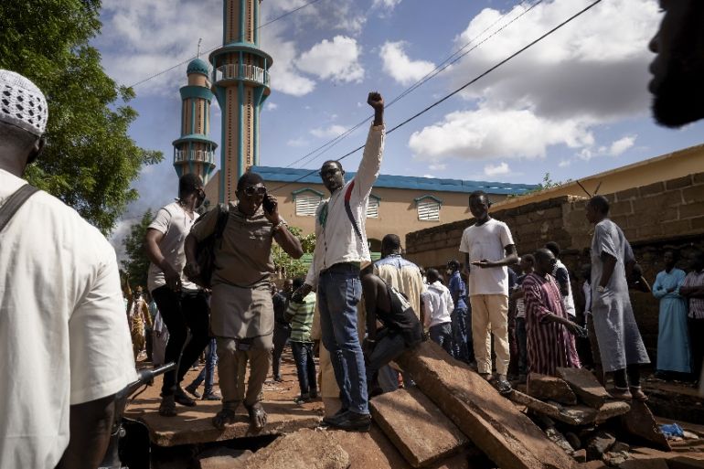 MALI-POLITICS-UNREST Protesters gestures on a barricade put up in front of the Salam mosque of Badalabougou, where the influent Imam Mahmoud Dicko led a prayer dedicated to the victims