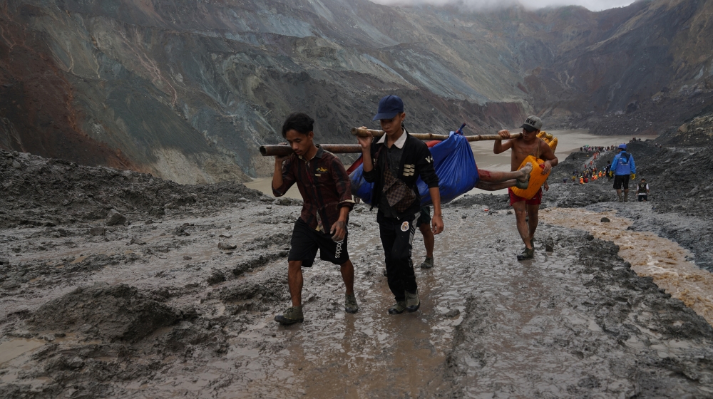 Rescuers recover a body near the landslide area in the jade mining site in Hpakhant in Kachin state on July 2, 2020. The battered bodies of more than 120 jade miners were pulled from a sea of mud afte