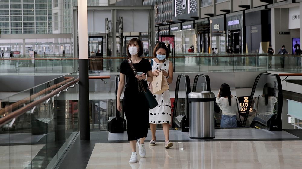 epa08544547 People walk through The Shoppes at the Marina Bay Sands in Singapore, 14 July 2020. Singapore's economy shrank a record 41.2 percent as a result of the circuit breaker measures implemented