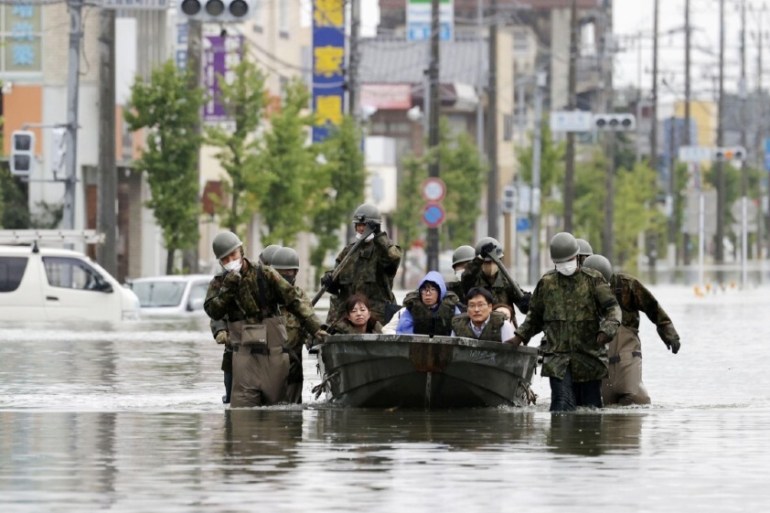 Local residents are rescued by Japanese Self-Defence Force soldiers using a boat at a flooding area caused by a heavy rain in Kuma village, Kumamoto prefecture, southern Japan, in this photo taken by