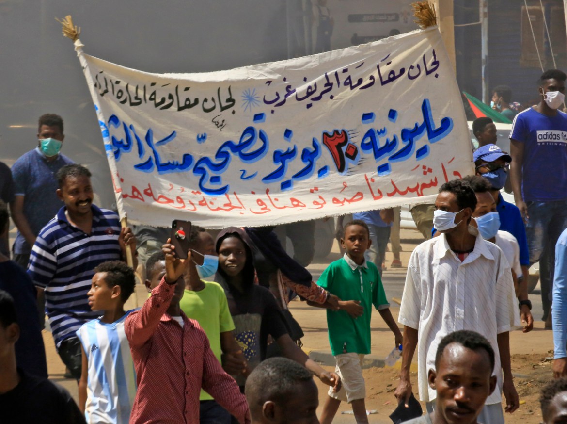 Sudanese demonstrators lift a banner which reads "June 30''s million-strong protest to put the revolution back on course" during a protest on Sixty street in the east of the capital Khartoum, on June 3