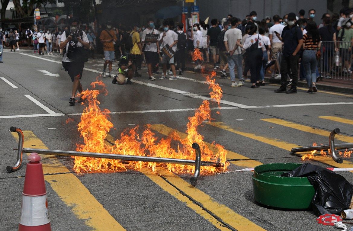 epa08519494 Protesters set fire to a barricade in an attempt to block a road during a rally against a new national security law, on the 23rd anniversary of the establishment of the Hong Kong Special A