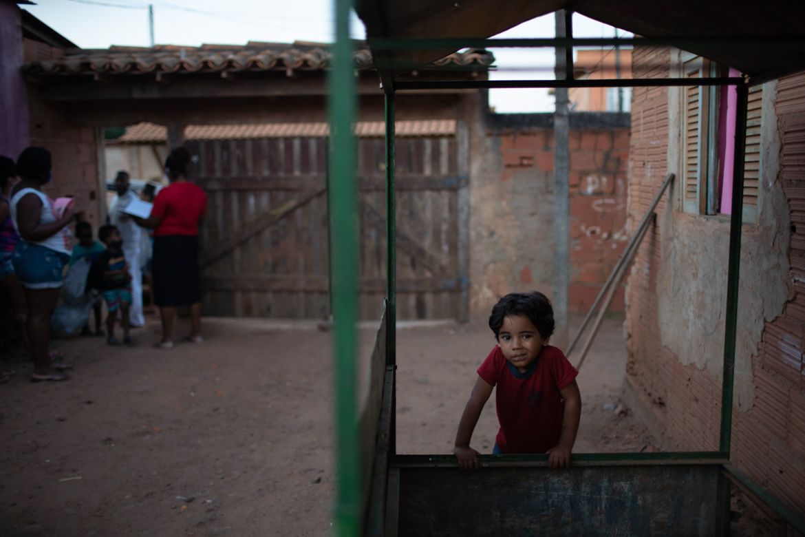A boy leans on an empty kiosk as donated food, kits of cleaning products and protective face masks are distributed amid the new coronavirus pandemic, at the Maria Joaquina "Quilombo" in Cabo Frio, on