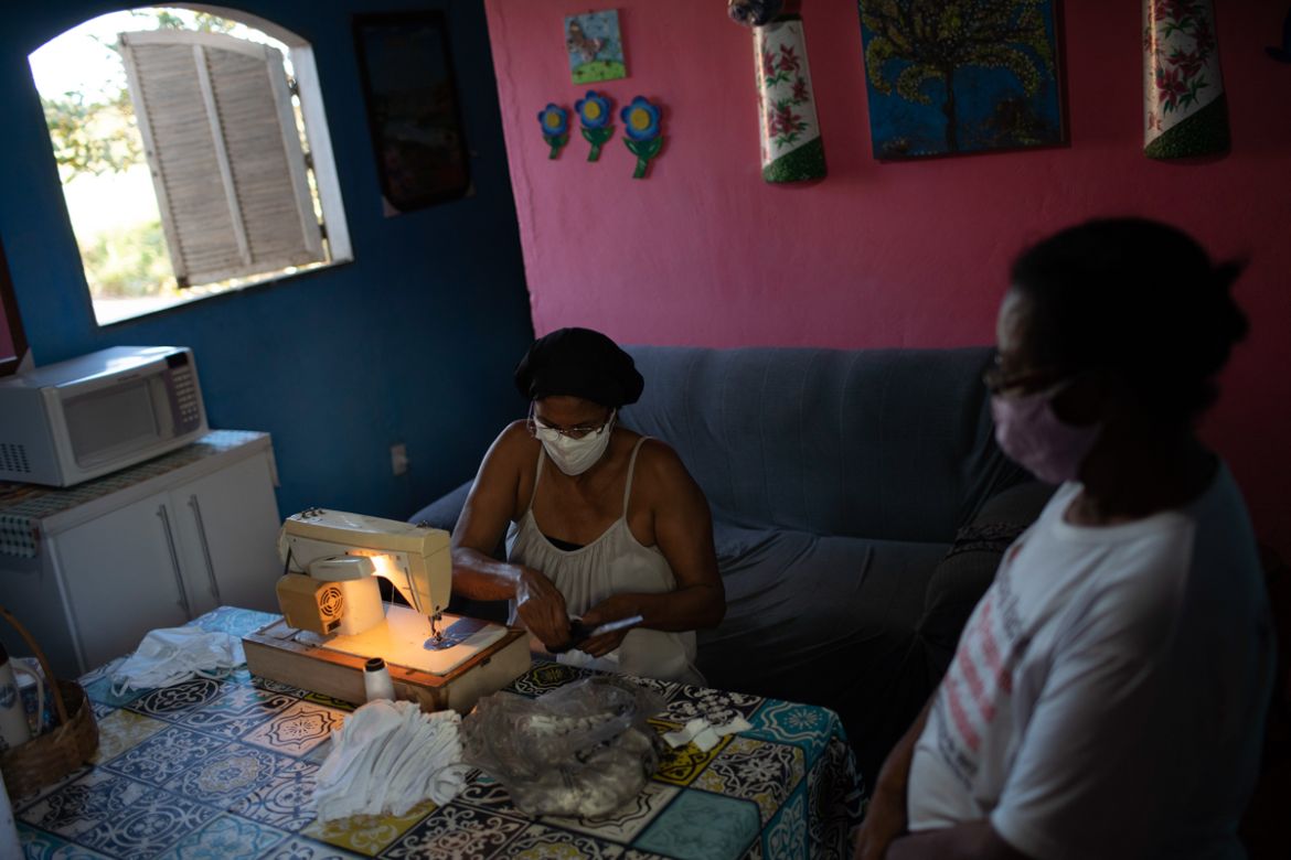 Rosane Da Franca, left, sews protective face masks at her home at the Maria Joaquina "Quilombo" in Cabo Frio, on the outskirts of Rio de Janiero, Brazil, Sunday, July 12, 2020. Rosane takes part in a