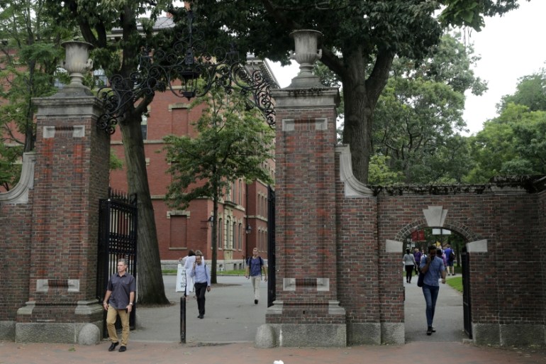 Pedestrians walk through the gates of Harvard Yard at Harvard University in Cambridge, Mass., Tuesday, Aug. 13, 2019. (AP Photo/Charles Krupa)