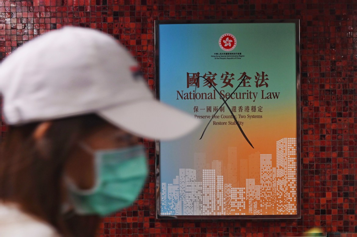 epa08519364 A commuter walks past a vandalised poster promoting the new national security law, in a subway station in Hong Kong, China, 01 July 2020. Chinese President Xi Jinping has signed into law t