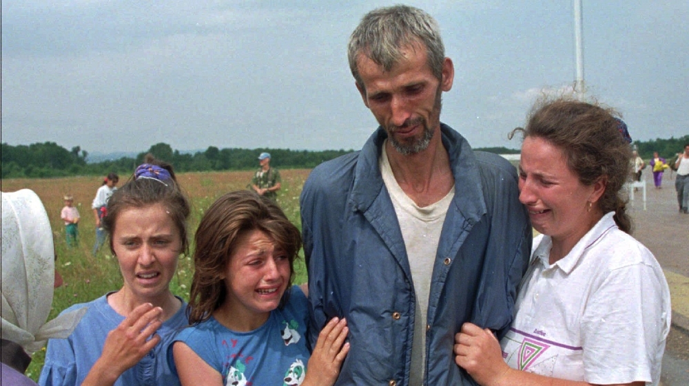 FILE - In this Monday July 17, 1995 file photo, Bosnian refugees cry as their father and husband arrives at the U.N. air base in Tuzla, Bosnia, after he survived the death march of six days from Srebr