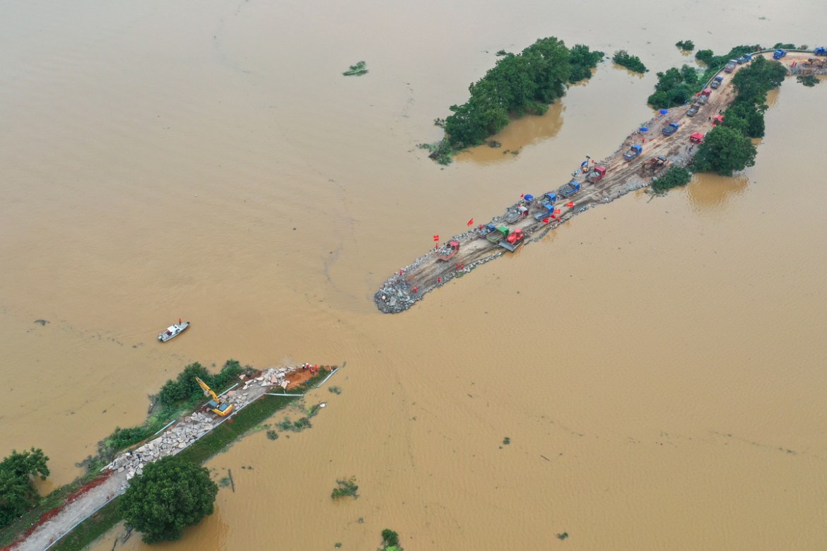This aerial view shows workers (C) repairing a breached dam due to flooding in Jiujiang in China''s central Jiangxi province on July 13, 2020. - Floods across central and eastern China have left more t