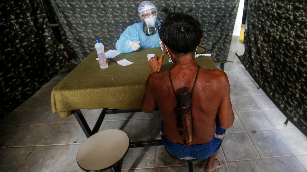 A member of Brazilian Armed Forces medical team examines a man from the indigenous Yanomami ethnic group, amid the spread of the coronavirus disease (COVID-19), at the 4th Surucucu Special Frontier Pl