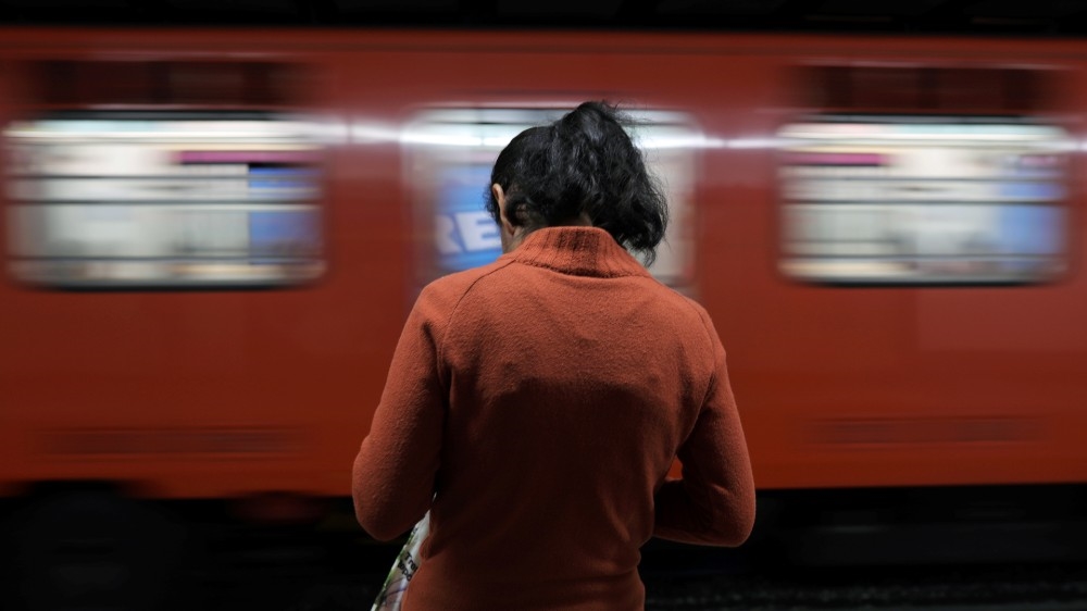A woman waits at a subway station during the 