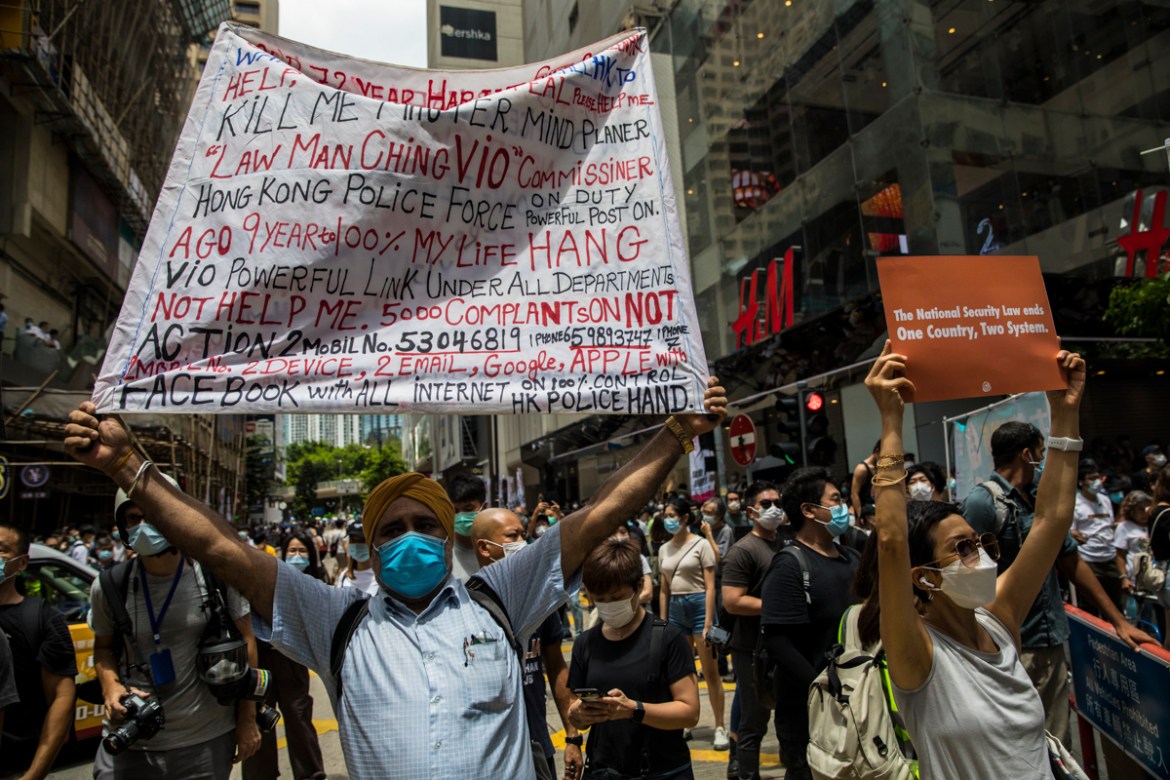 Protests display banners during a rally against a new national security law in Hong Kong on July 1, 2020, on the 23rd anniversary of the city''s handover from Britain to China. - A man found in possess