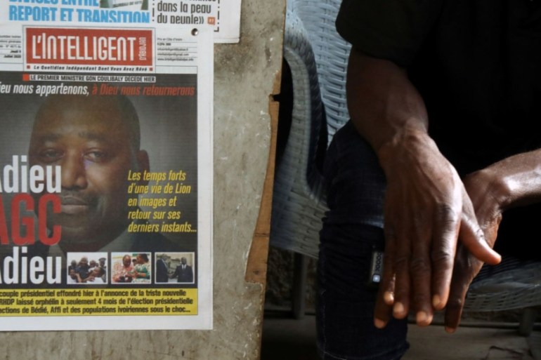 A man sits next to newspapers a day after the death of Ivory Coast''s prime minister Amadou Gon Coulibaly in Abidjan