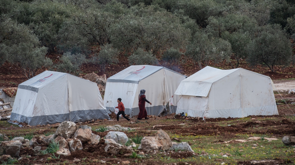 Displaced Syrians walk past their makeshift tents build near olive trees near the village of Atmeh on February 22, 2020 in Idlib, Syria. Turkey’s President Recep Tayyip Erdogan in a speech Tuesday thr