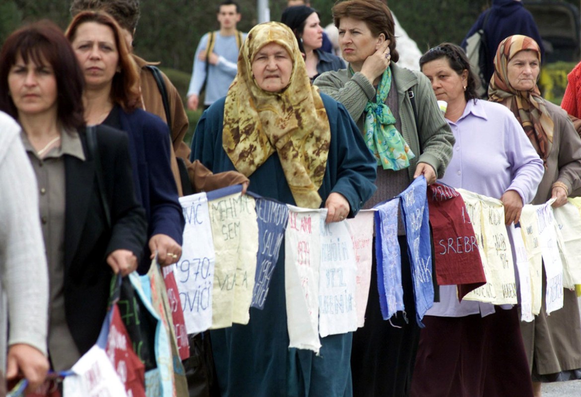 Bosnian Muslims, survivors of the 11 July 1995 Serbrenica massacre, hold a line of posters with the name of their missing relatives 11 April 2003 in the central Bosnian town of Tuzla. The demonstrator