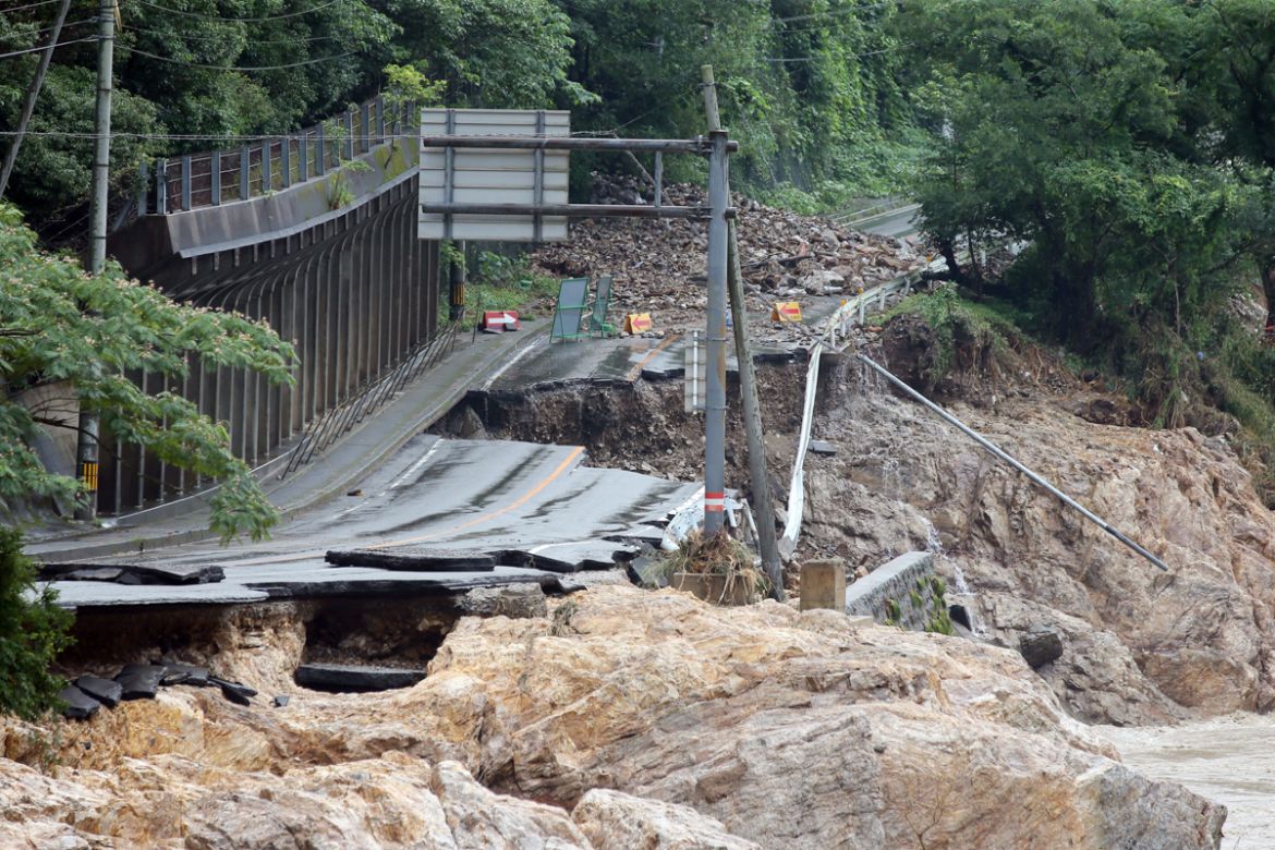 epa08529885 A road is destroyed due the floods near the Kuma river in Ashikita, Kumamoto prefecture, Japan, 06 July 2020. According to latest madia reports, 39 people are feared to have died and at le