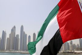 UAE flag flies over a boat at Dubai Marina,