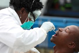 A member of medical staff swabs the mouth of a resident for a medical test, during a nationwide lockdown to try to contain the COVID-19 outbreak, in Alexandra, South Africa, March 31, 2020 [Siphiwe Sibeko/Reuters]