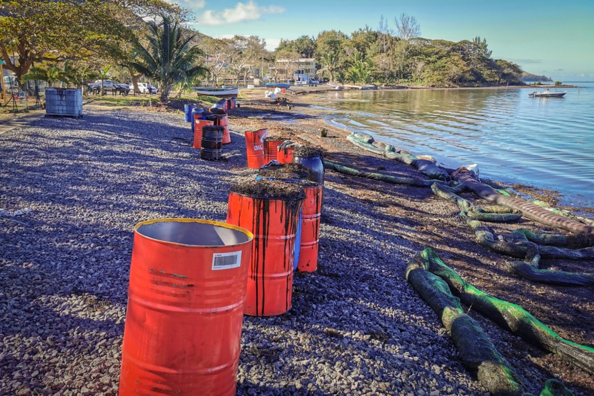 (EDITORS NOTE: Best quality available.) Drums filled with fuel oil waste and algae sit behind foam-filled oil containment booms on shore at Bois des Amourettes, Mauritius, on Friday Aug. 14, 2020. The