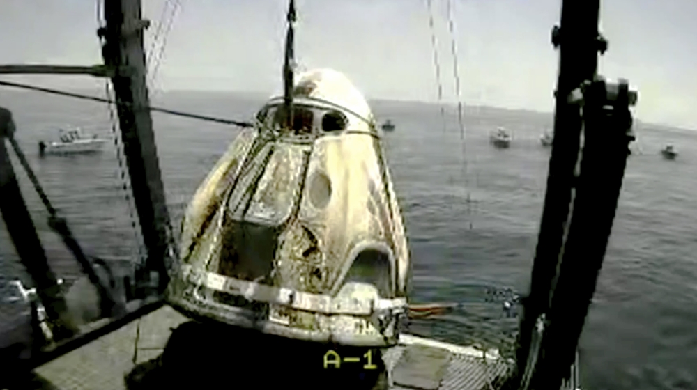 In this frame grab from NASA TV, the SpaceX capsule is lifted onto a ship, Sunday, Aug. 2, 2020 in the Gulf of Mexico. Astronauts Doug Hurley and Bob Behnken spent a little over two months on the Inte