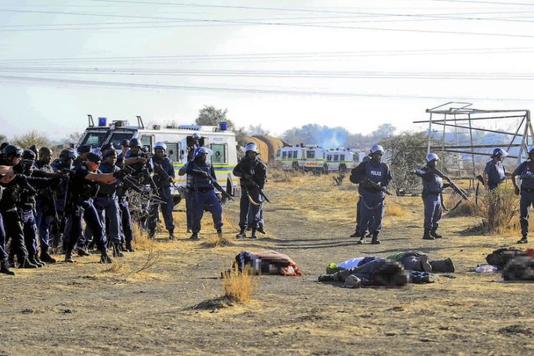 epa03363273 South African police check the bodies of striking mineworkers shot dead at the Wonderkop informal settlement near Marikana platinum mine, Rustenburg, South Africa, 16 August 2012. Reports