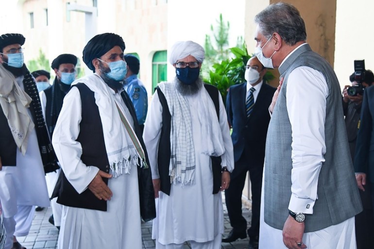In this handout photograph taken on August 25, 2020, and released by the Pakistan Foreign Ministry, Pakistan''s Foreign Minister Shah Mehmood Qureshi (R) greets Taliban co-founder Mullah Abdul Ghani Ba