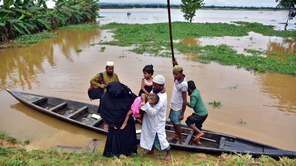 Flood-affected villagers disembark a boat after they reached a safer place at Kachua village