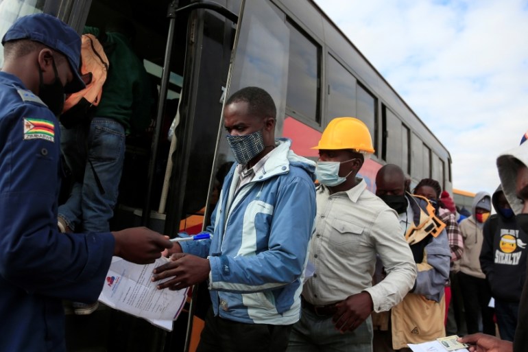 Police and soldiers check bus passengers during the coronavirus disease (COVID-19) outbreak in Harare