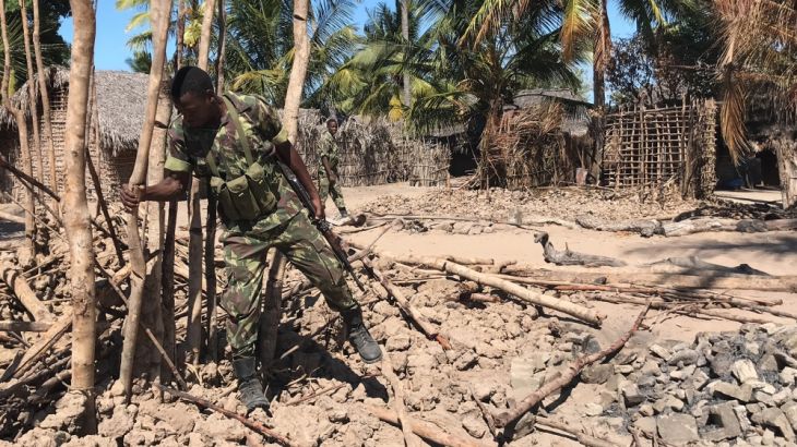 Mozambican Army soldiers bring down a structure torched by attackers to be rebuilt as shelter for people fleeing the recent attacks, in Naunde, northern Mozambique, on June 13, 2018. Until last week,
