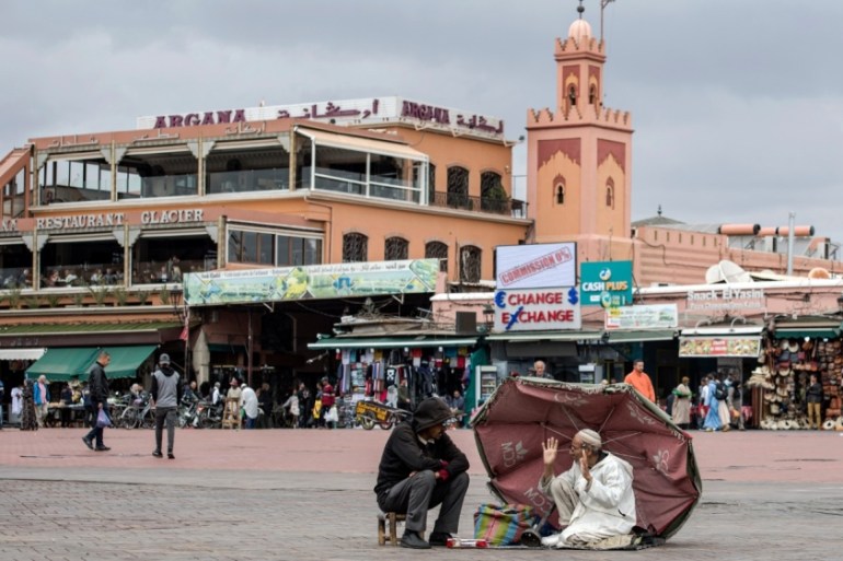 Moroccans sit at Marrakesh's Jemaa el-Fna square.