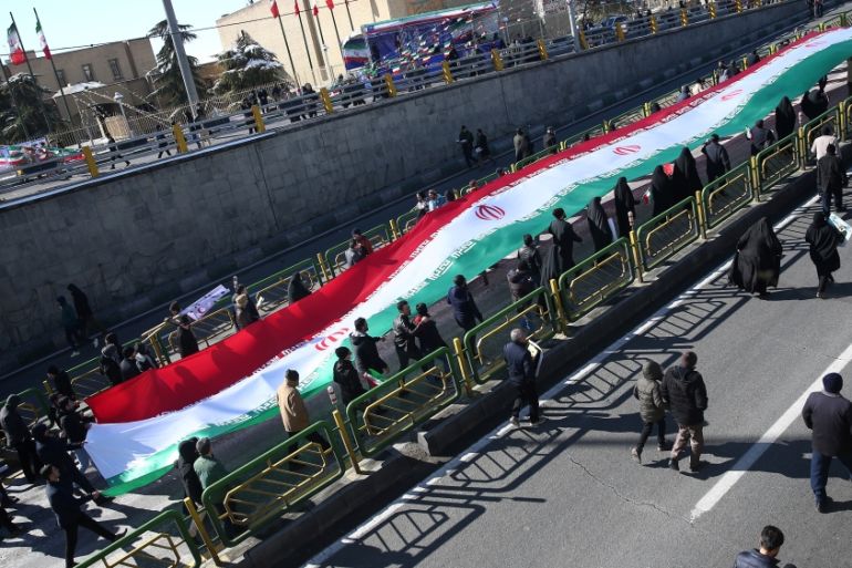 Iranians carry the Iranian flag as they gahter during the commemoration of the 41st anniversary of the Islamic revolution in Tehran