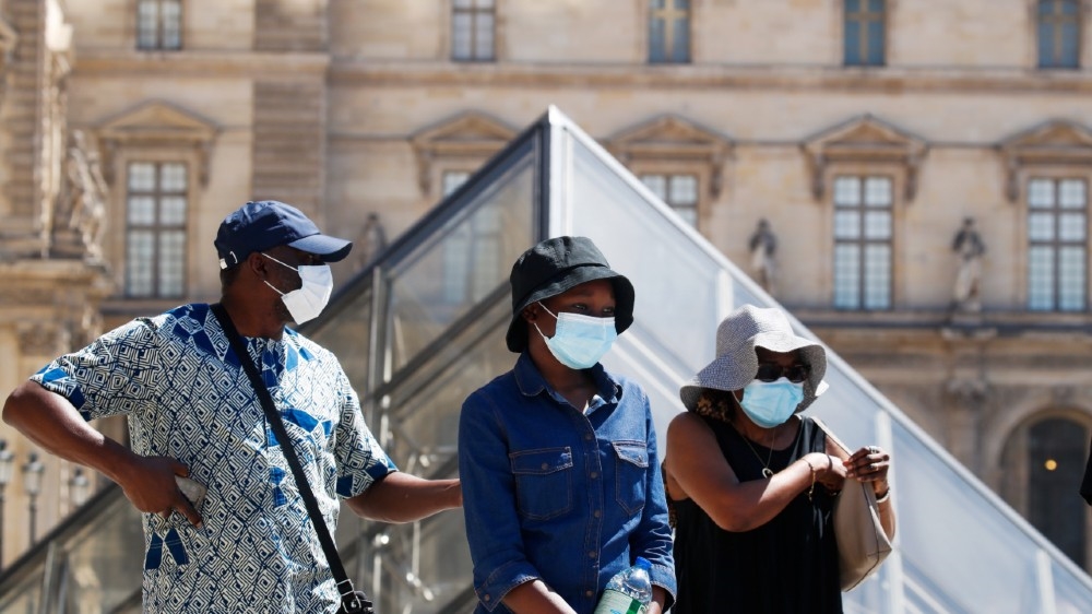 People wearing protective masks walk near the Louvre Museum as France reinforces mask-wearing as part of efforts to curb a resurgence of the coronavirus disease (COVID-19) 
