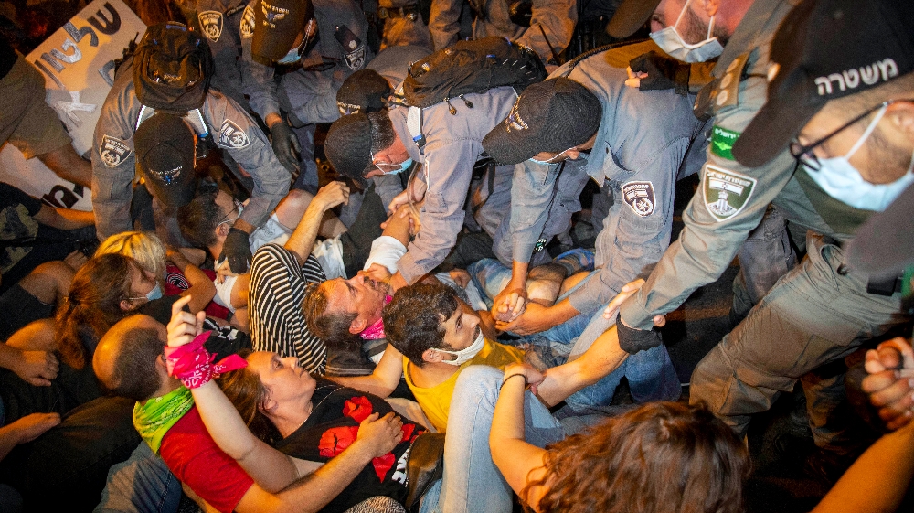 Police clear off protesters who blocked a main road during a protest against Israel's Prime Minister Benjamin Netanyahu outside his residence in Jerusalem early Sunday, Aug 2, 2020.
