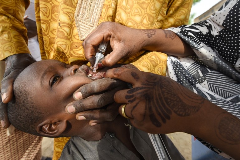A Health worker administers a vaccine to a child during a vaccination campaign against polio at Hotoro-Kudu, Nassarawa district of Kano in northwest Nigeria. The World Health Organization (WHO) is to