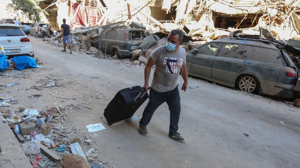 A man pushes his belongings along a street as he evacuates his damaged house, following Tuesday's blast in Beirut's port area, Lebanon August 5, 2020. REUTERS/Aziz Taher