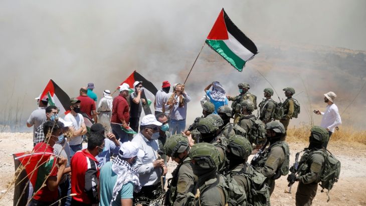 Palestinian demonstrators gather in front of Israeli forces during a protest against Israel''s plan to annex parts of the occupied West Bank, Asira ash-Shamaliya near Nablus July 3, 2020. REUTERS/Ranee